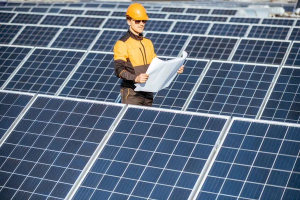 Engineer with blueprints on a solar station — Stock Photo, Image