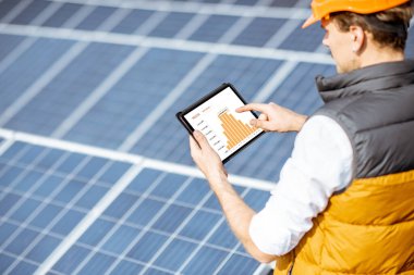 Dijital tabletle güneş enerjisi santralinin üretimini inceliyor