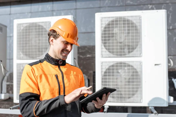Workman servicing air conditioning or heat pump with digital tablet — Stock Photo, Image