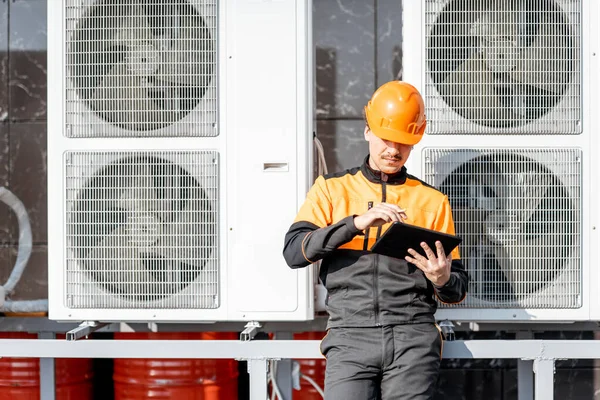 Workman servicing air conditioning or heat pump with digital tablet — Stock Photo, Image