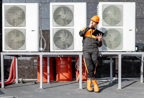 Workman servicio de aire acondicionado o bomba de calor con tableta digital —  Fotos de Stock