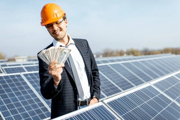 Businessman with money on a solar power plant
