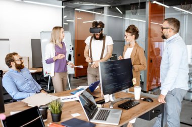 Ofis çalışanları VR gözlükleri ile konferans yapıyorlar.