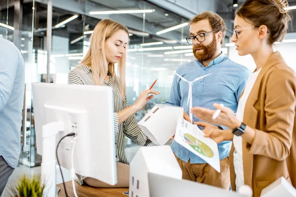 Groupe de personnes travaillant sur un projet d'énergie alternative au bureau — Photo