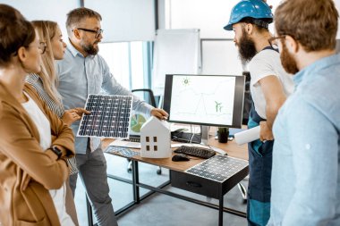 Ofiste alternatif enerji projesi üzerinde çalışan insanlar