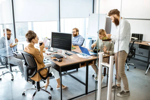 Office workers eating salad in the office — Stock fotografie