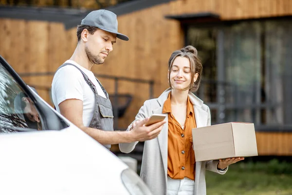 Entrega homem entregando mercadorias para uma mulher em casa de carro — Fotografia de Stock