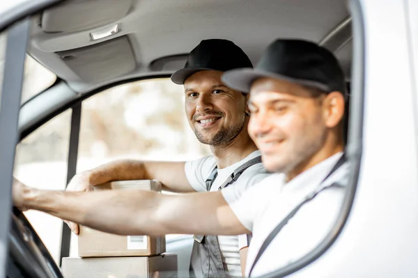 Empleados de la empresa de entrega conduciendo un vehículo — Foto de Stock