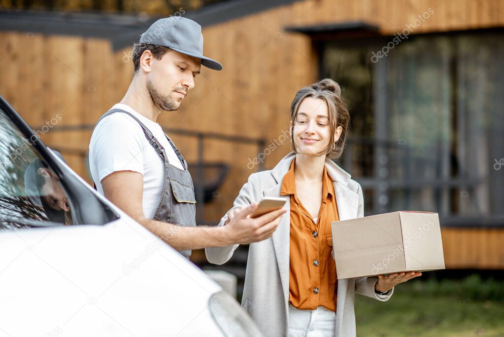 Delivery man delivering goods to a woman home by car