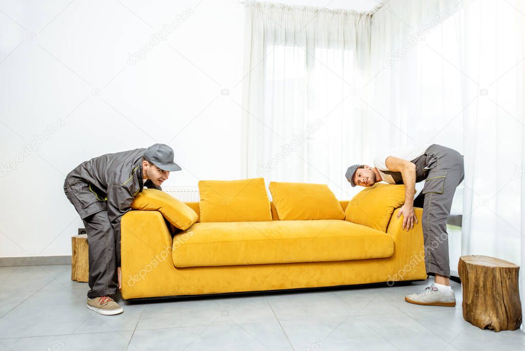 Movers placing sofa at home