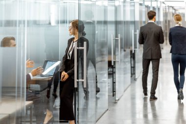 Modern ofis binasının koridorundaki iş adamları.