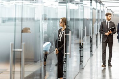 Modern ofis binasının koridorundaki iş adamları.