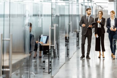 Modern ofis binasının koridorundaki iş adamları.