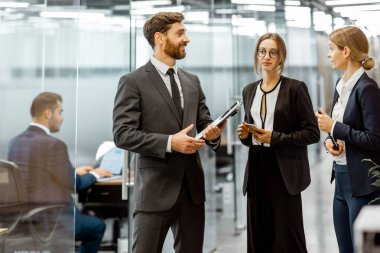 Modern ofis binasının koridorundaki iş adamları.