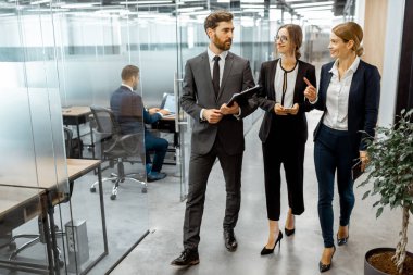 Modern ofis binasının koridorundaki iş adamları.