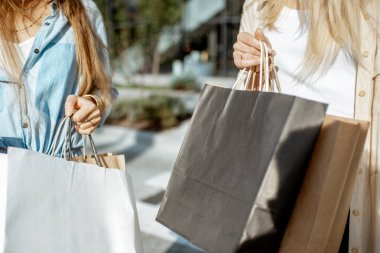 Alışveriş merkezinin yakınındaki alışveriş torbalı kadınlar.