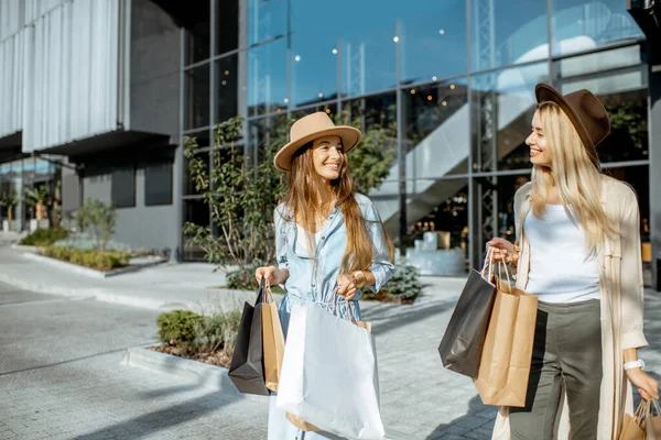 Женщины с сумками возле торгового центра на открытом воздухе — стоковое фото