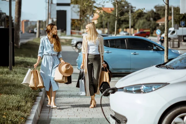 Women walking with shopping bags on the parking — ストック写真
