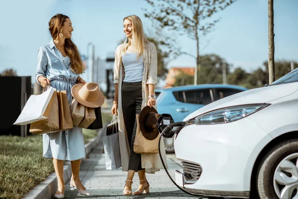 Mulheres caminhando com sacos de compras no estacionamento — Fotografia de Stock