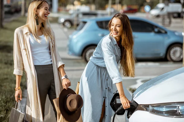 Žena nabíjení elektrické auto — Stock fotografie