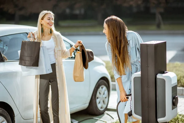 Žena nabíjení elektrické auto — Stock fotografie