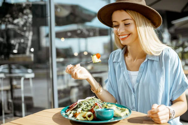 Kafe terasında salata yiyen bir kadın. — Stok fotoğraf