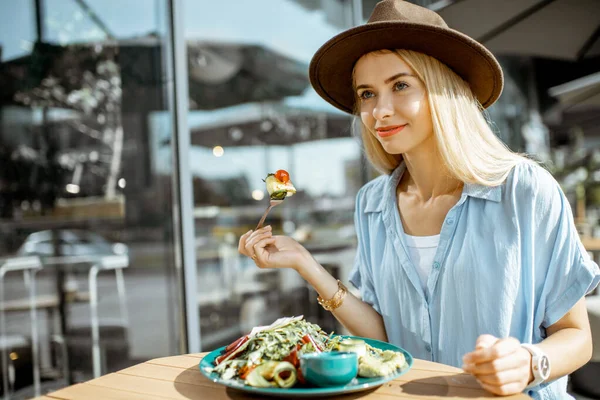 Mujer comiendo ensalada en una terraza cafetería — Foto de Stock