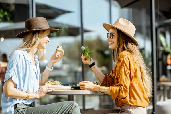 Vriendinnen die gezond eten op een terras — Stockfoto