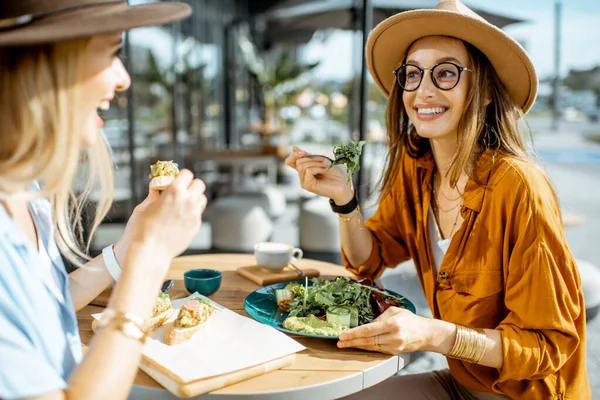 テラスで健康的な食べ物を食べるガールフレンド — ストック写真