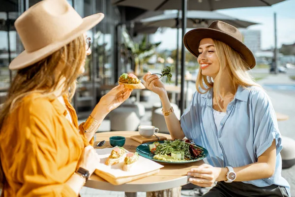 Подружки їдять здорову їжу на терасі — стокове фото