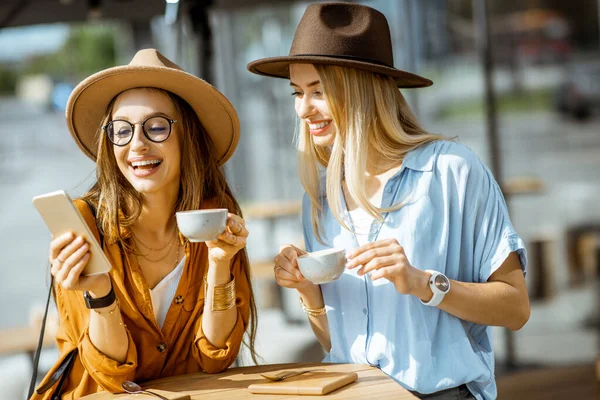 Girlfriends spending time together on a cafe terrace — Stock Photo, Image