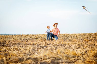 Arazide uçurtma uçuran baba oğul