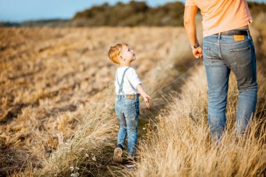 Baba ve oğul tarlada yürüyor.