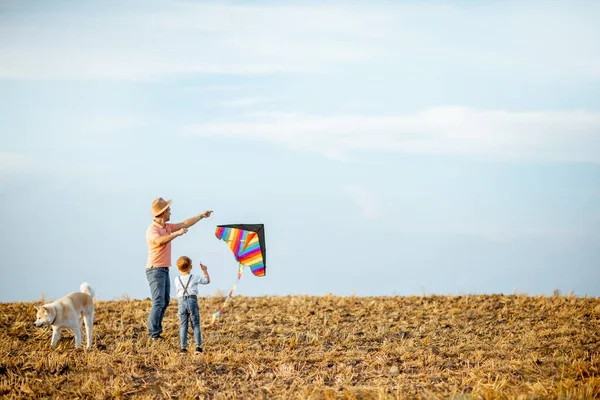 Fother et son fils volant cerf-volant sur le terrain — Photo