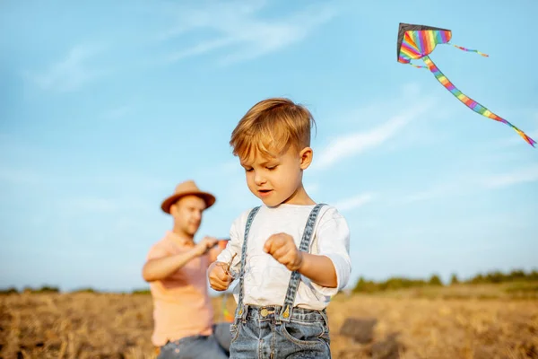 Fother and son flying kite on the field — 图库照片