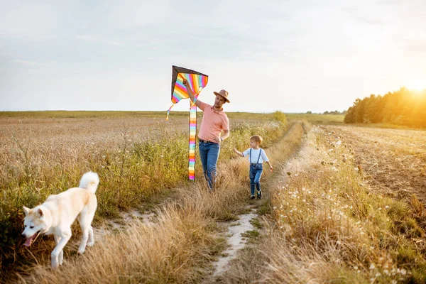 Père et fils marchant avec cerf-volant sur le terrain — Photo