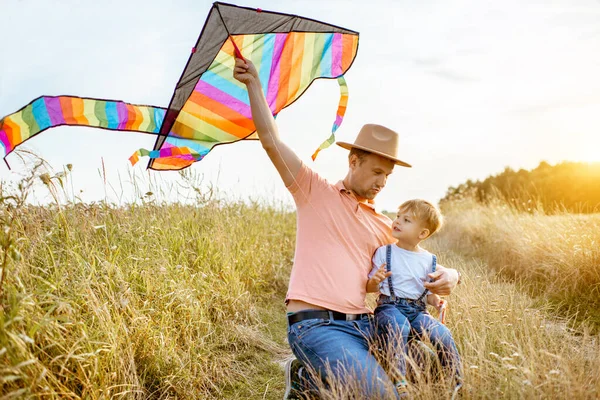 Father and son with kite on the field — Stock Photo, Image