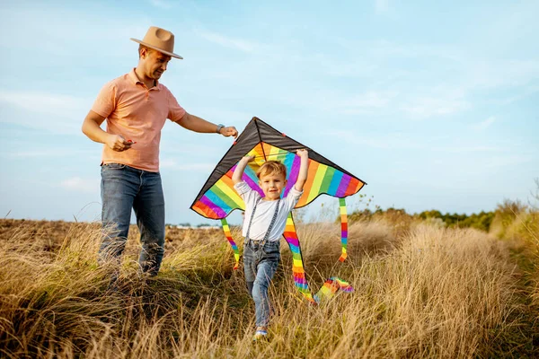 Pai e filho com pipa de ar no campo — Fotografia de Stock