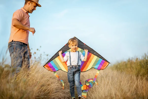 Padre e hijo con cometa de aire en el campo — Foto de Stock