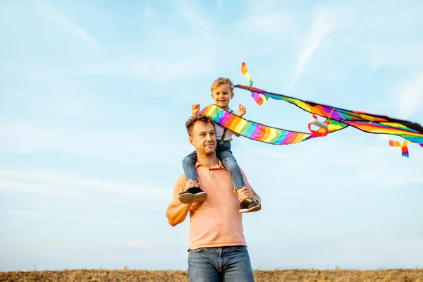 Vader en zoon met vlieger buiten — Stockfoto