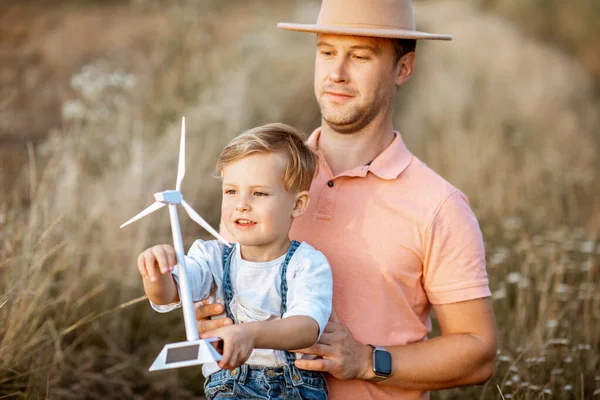 Père et jeune fils jouant avec l'éolienne — Photo