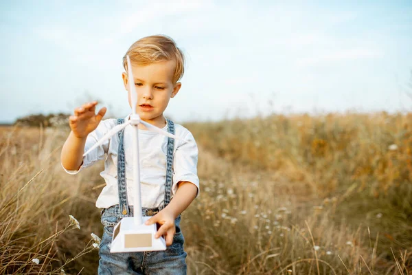 Boy playing with toy wind turbine outdoors — Stock Photo, Image