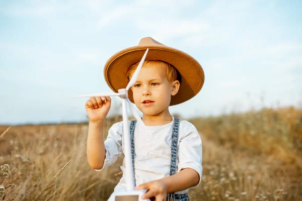 Boy playing with toy wind turbine outdoors — Stock Photo, Image