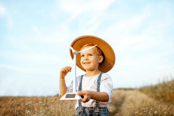 Jongen spelen met speelgoed windturbine buiten — Stockfoto