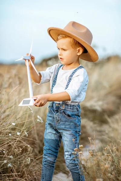 Poika leikkii lelu tuuliturbiini ulkona — kuvapankkivalokuva