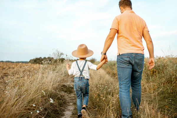 父と息子が野原を歩いていると — ストック写真