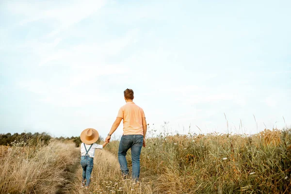 Father and son walking in the field — Stock Photo, Image