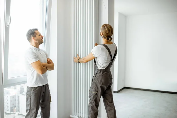 Pracovníci instalující radiátor doma — Stock fotografie