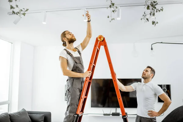 Mannen die thuis verlichting installeren — Stockfoto