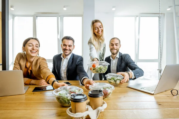 Office employees with healthy takeaway food indoors